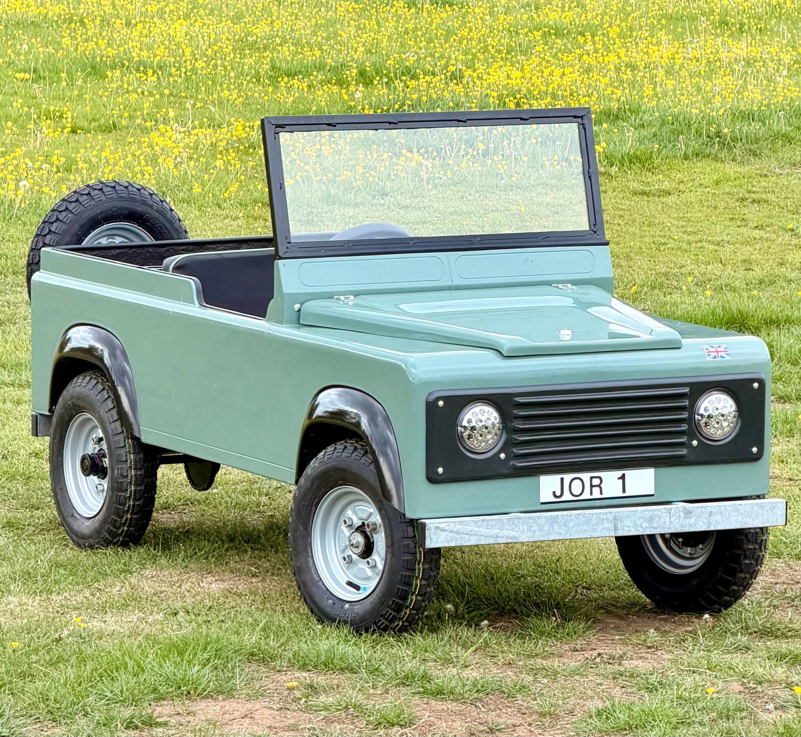 JOR 1, the pastel green mini Land Rover in a buttercup meadow