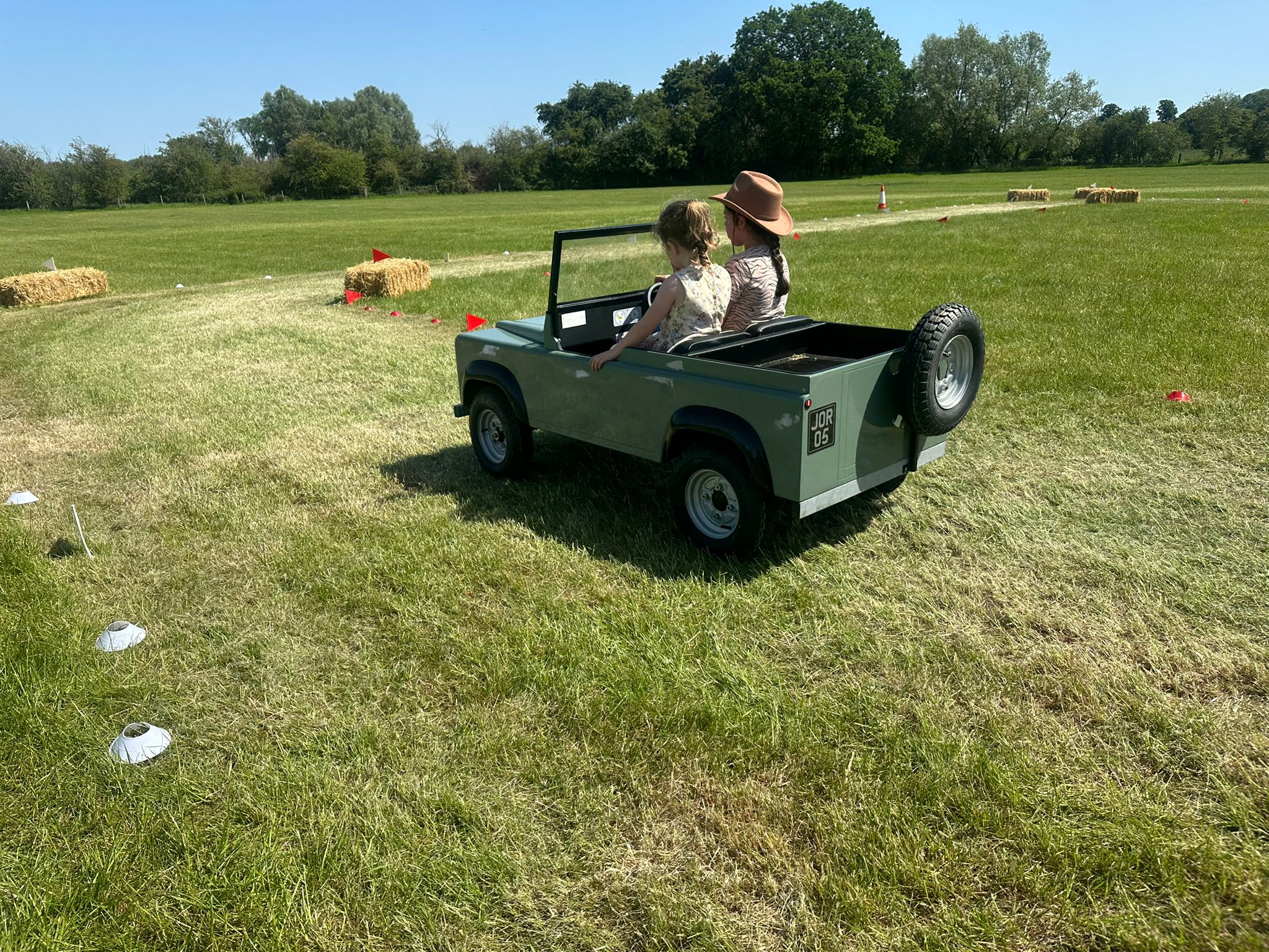 Children driving the pastel green mini Land Rover at the Oxfordshire Young Farmers Country Show