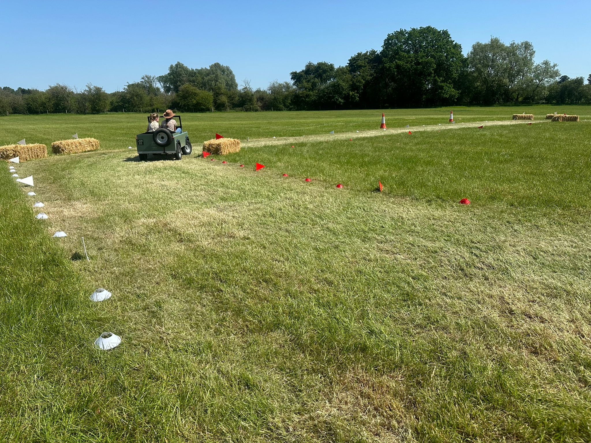 Wide view of the show course, with cones and hay bales marking the track