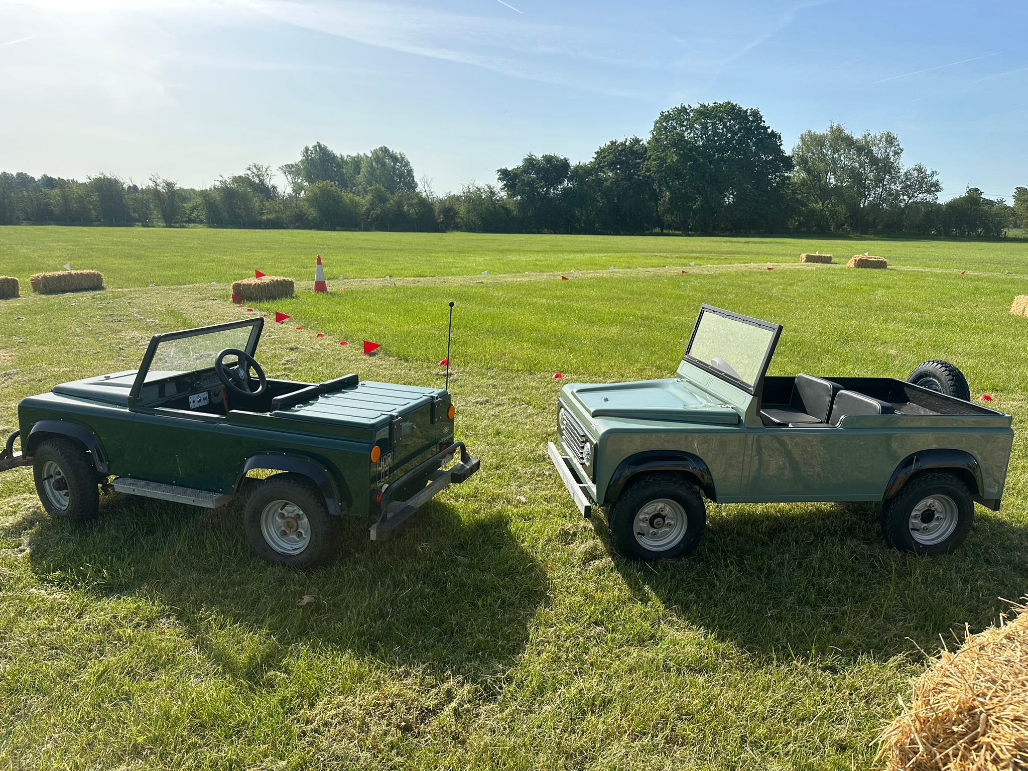 Both mini Land Rovers set up side by side at a country show